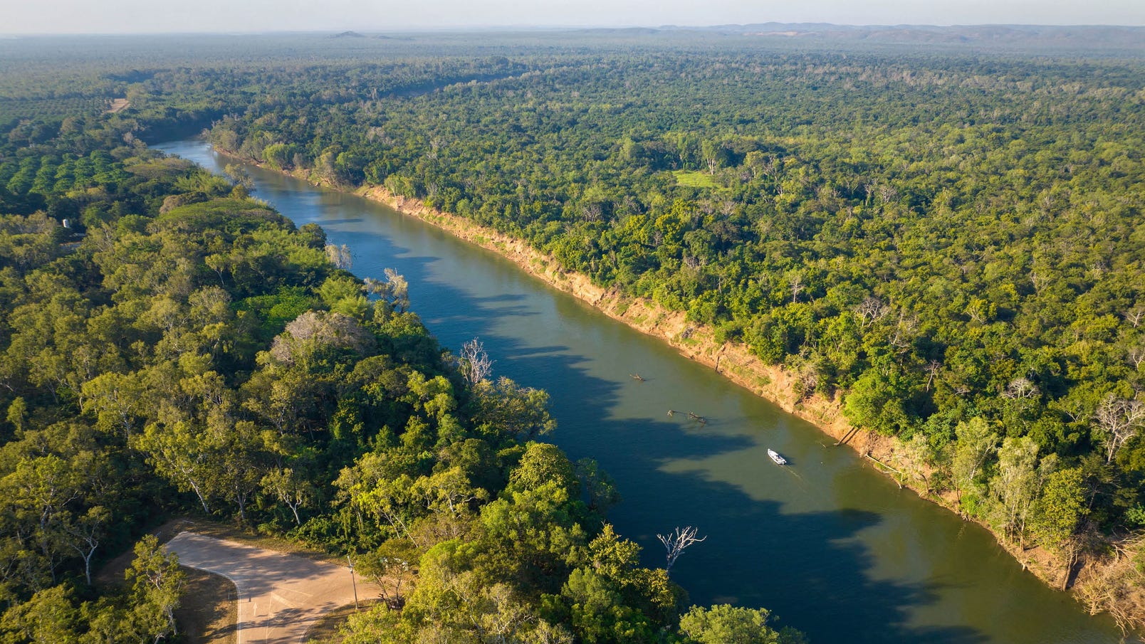 aerial view of the daly river with a boat travelling down the water