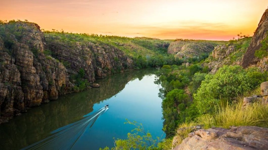 a small boat cruising through nitmiluk gorge in katherine