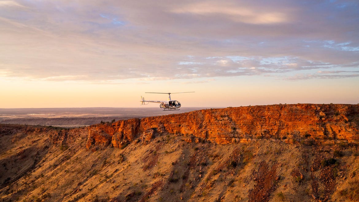 an alice springs helicopter flying over the west macdonnell ranges