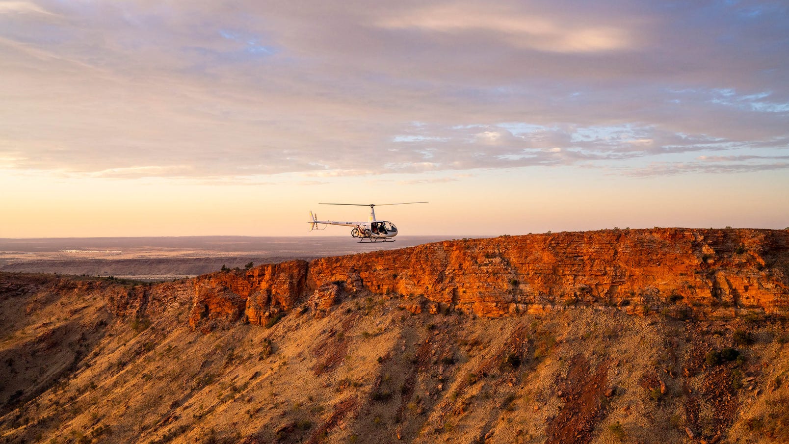 an alice springs helicopter flying over the west macdonnell ranges