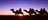 Silhouettes of people camel riding at sunrise near Uluru