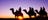 Silhouettes of people camel riding at sunrise near Uluru