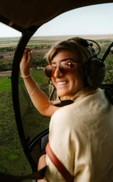 Girl on a Top End helicopter tour looking over the shoulder at the camera