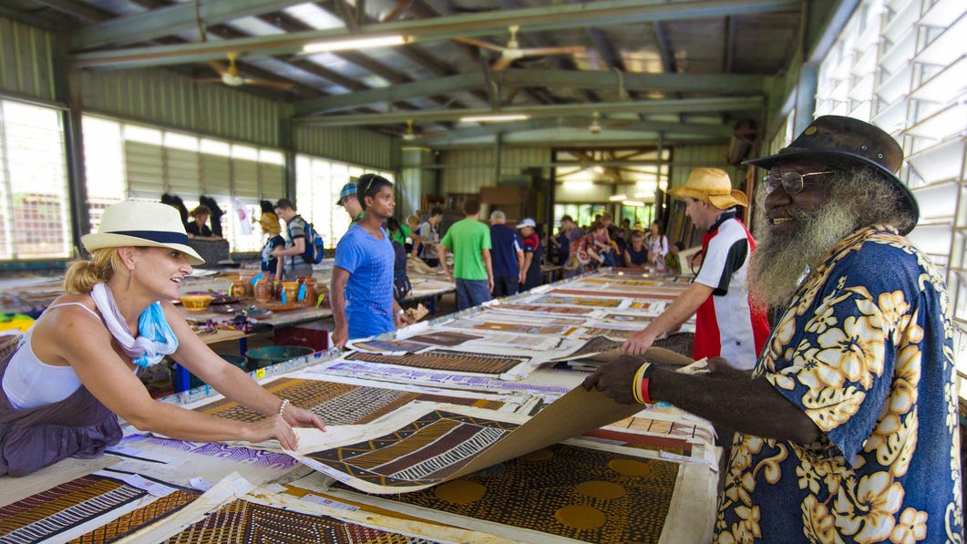People at an art centre in Tiwi looking at paintings