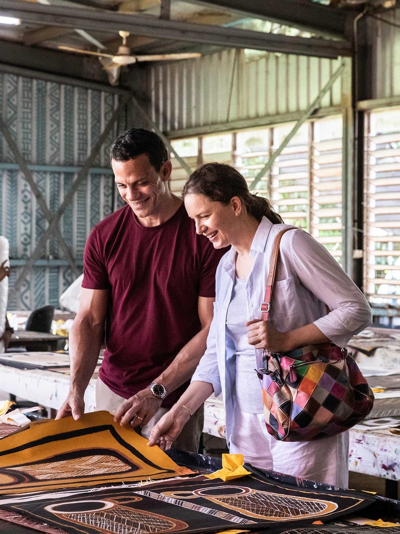 A couple looking at art in a shop in Tiwi Islands