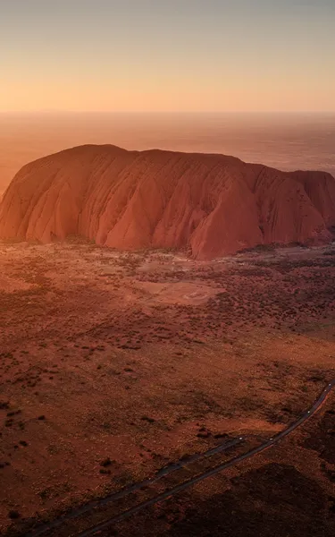 Aerial photo of a car road tripping to Uluru