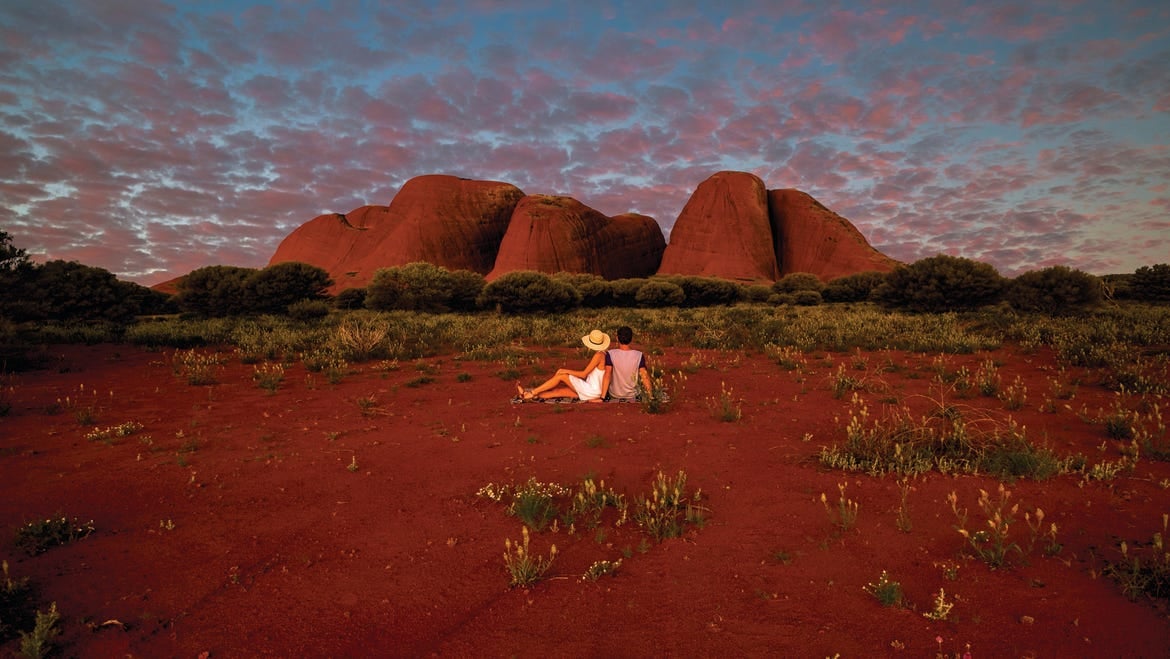 couple sitting in front of kata tjuta