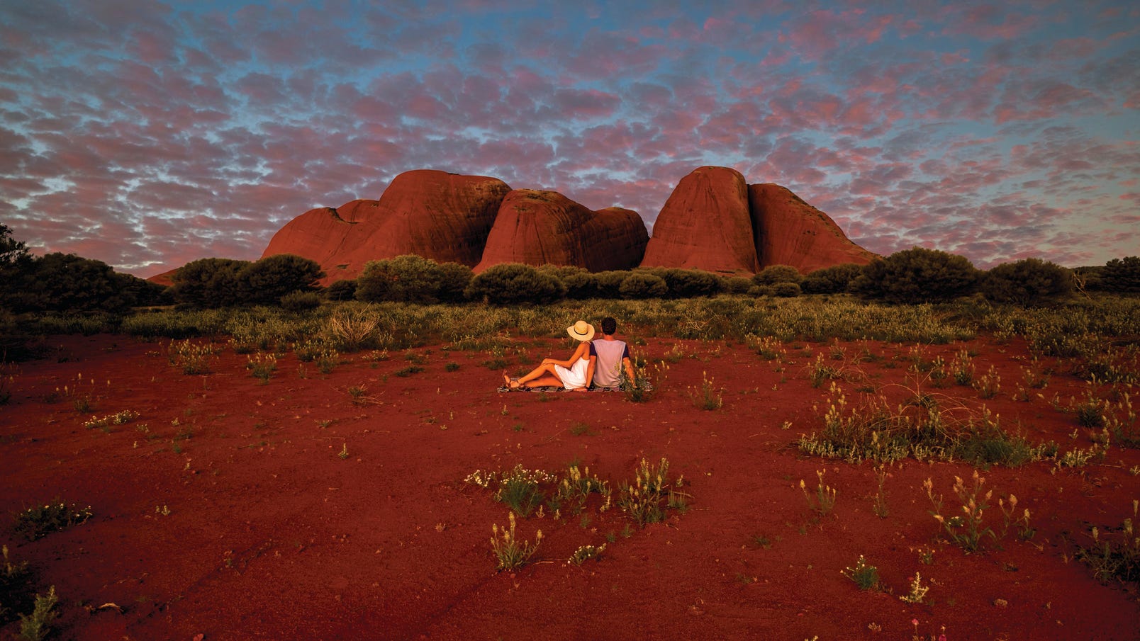 couple sitting in front of kata tjuta