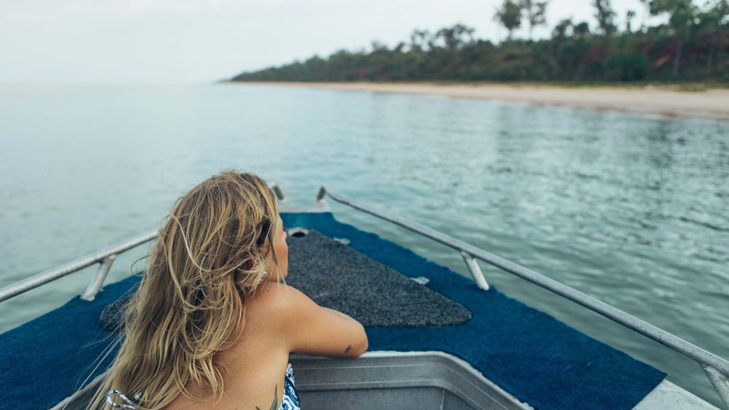 Emily Hutchinson watching from the front of the boat on the Tiwi Islands