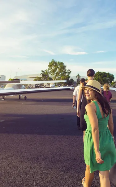 Group of people walking over to a plane at an airport