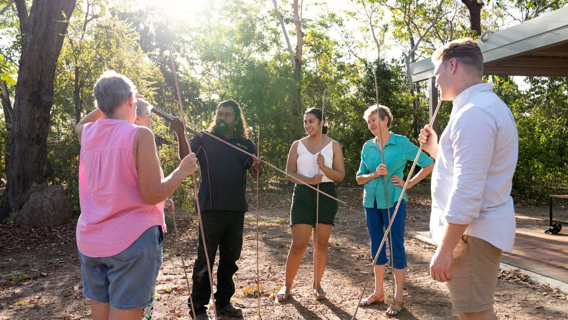 Visitors with spears listening to spear throwing from an Aboriginal guide at Adelaide River Wetland