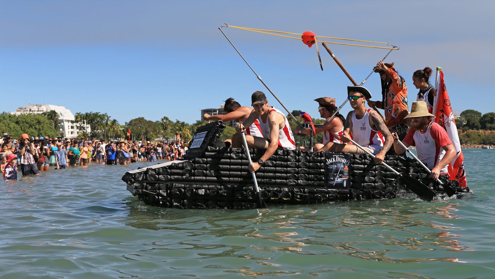 Competitors paddling a boat of beer cans during the Beer Can Regatta in Darwin