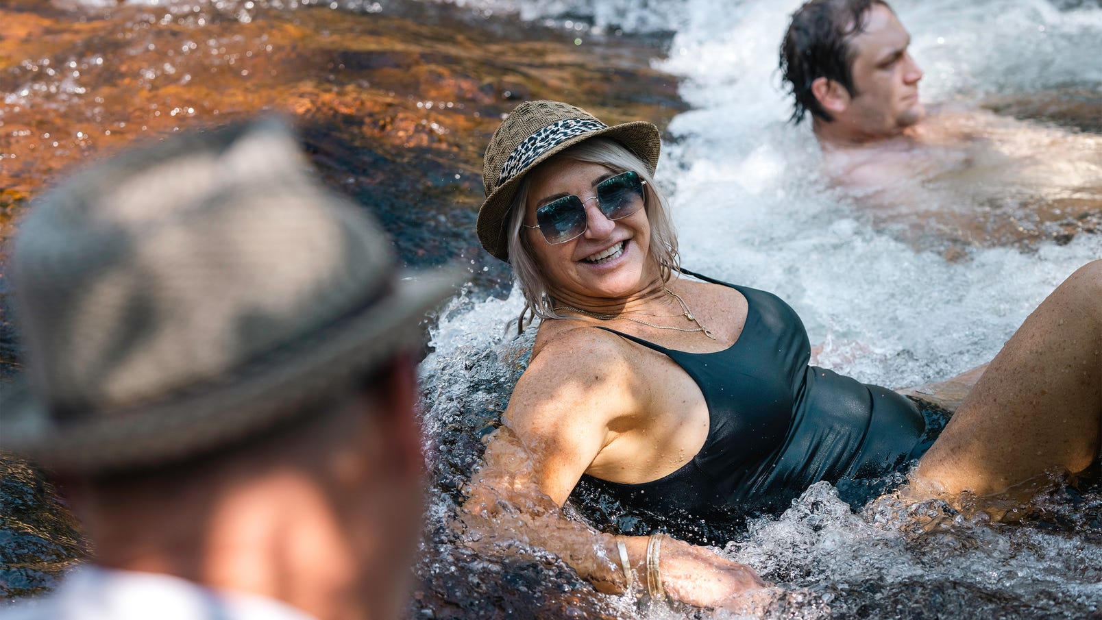 People-in-a-waterfall-with-Cyaround-Tours