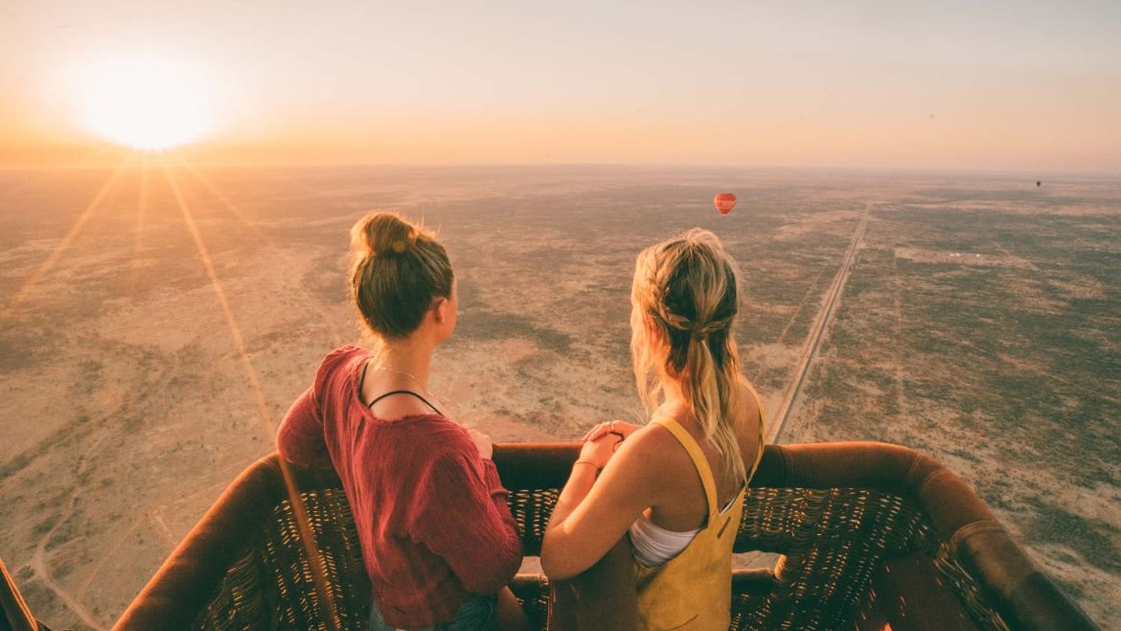 two girls enjoying sunrise over alice springs during a hot air balloon ride.jpg