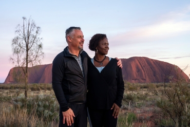 Two people standing in front of Uluru