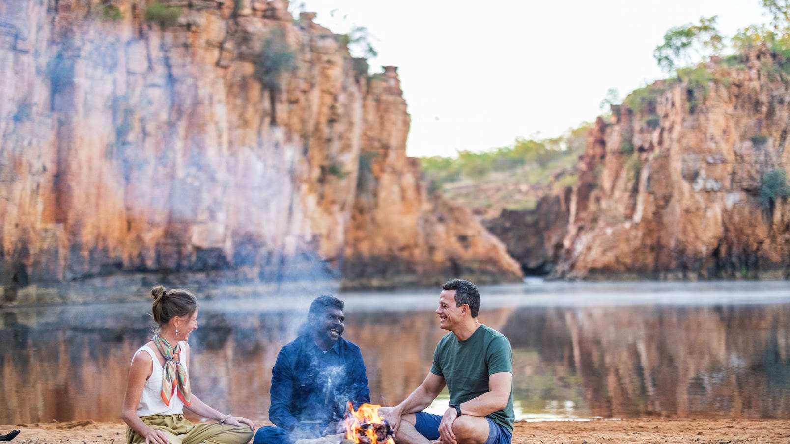 Three people sitting around a campfire on a cultural tour