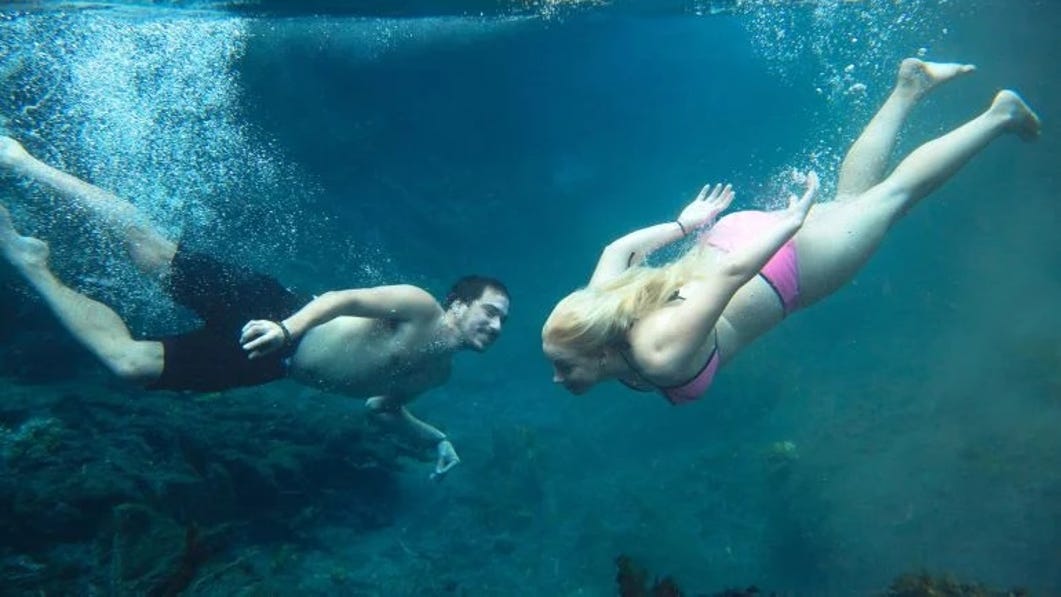 a couple swimming underwater at bitter springs in katherine