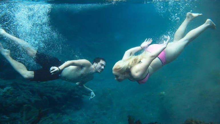 a couple swimming underwater at bitter springs in katherine