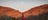 Woman in a red dress standing in front of the West MacDonnell Ranges in Alice Springs