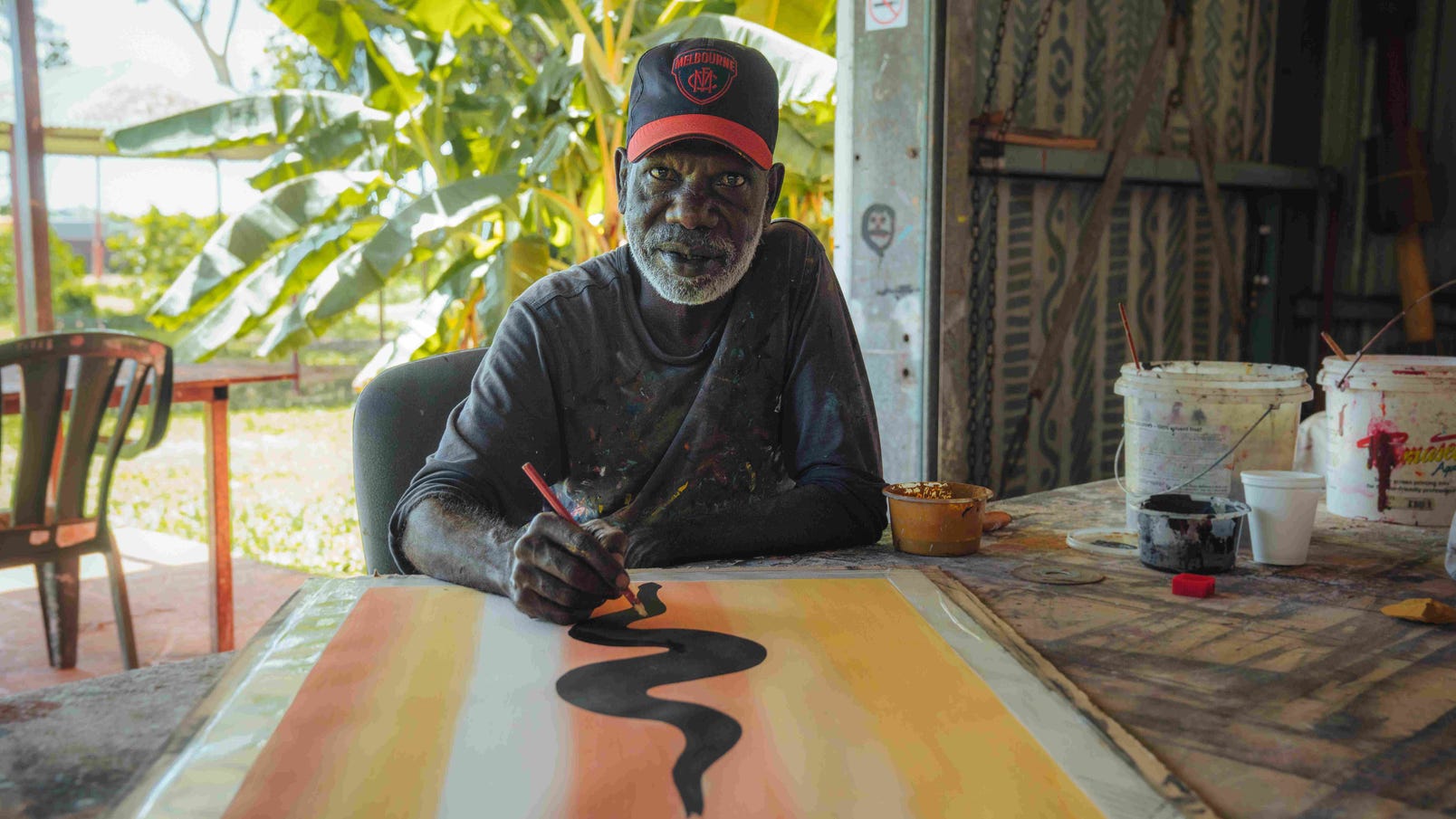 Aboriginal man painting an art work in Tiwi Islands