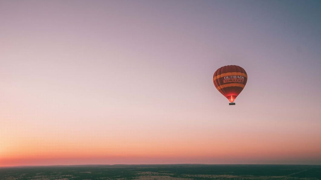 Hot air balloon in the sky at sunrise in Alice Springs.jpg