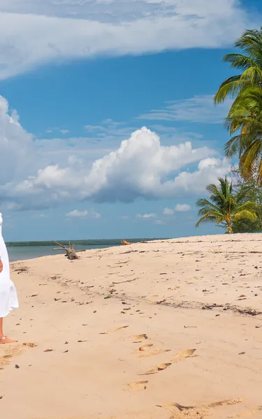 A woman on the beach looking at a low flying helicopter at Tiwi Island Retreat