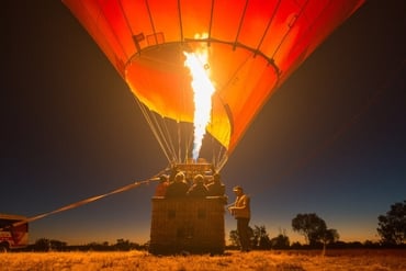 A hot air balloon being inflated before sunrise in Alice Springs