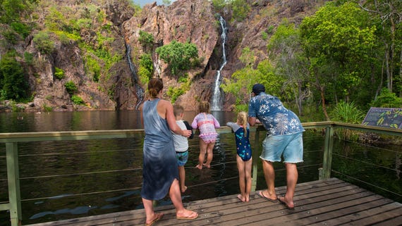 A family at the viewing platform in front of a waterfall in Litchfield National Park