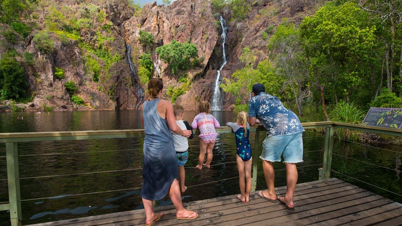 A family at the viewing platform in front of a waterfall in Litchfield National Park