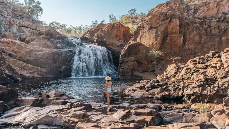 WOMAN NEAR WATERFALL
