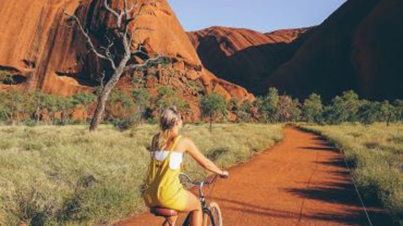 Girl riding a bicycle at Uluru.jpg