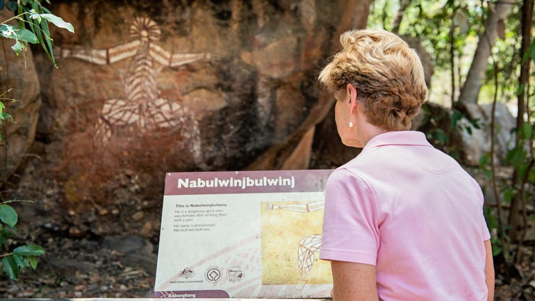 A lady looking at a Nourlangie Rock Art Site in Kakadu