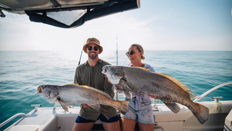 Two people holding up their big catches that they caught with yknot fishing charters in Darwin