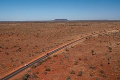 Driving the Red Centre Way with Mt Connor in the background