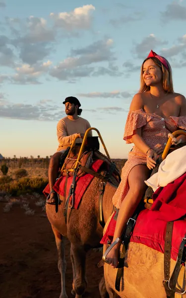 Two visitors on a camel tour near Uluru