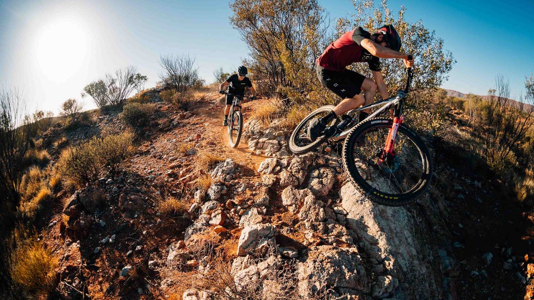 Wide action shot of a mountain biker riding in Alice Springs