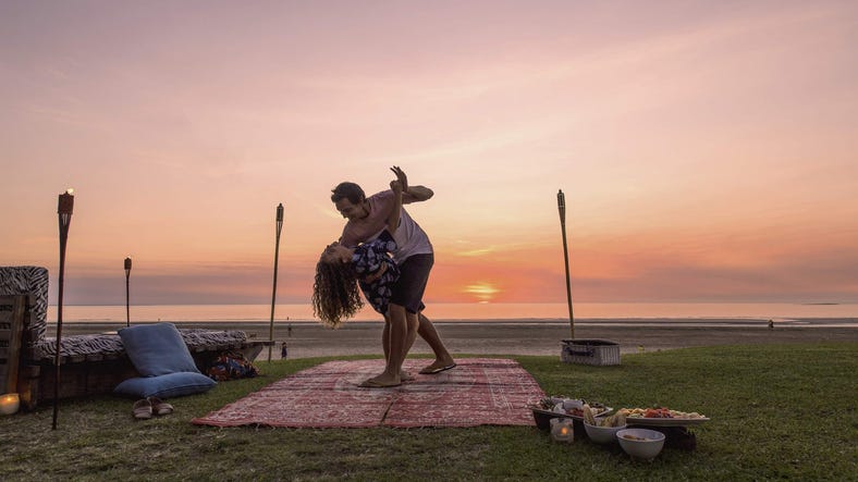 Couple dancing on Casuarina beach at sunset