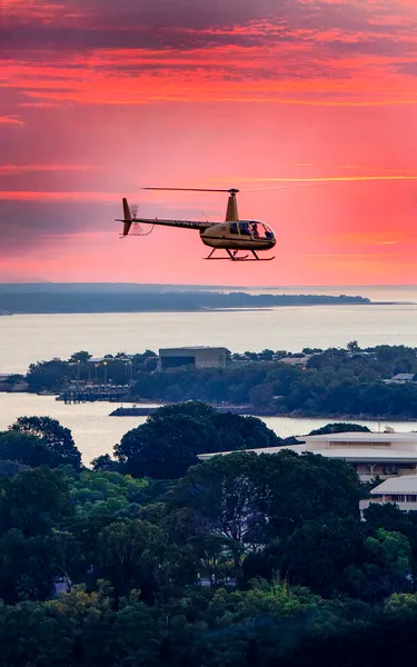 Airborne Solutions helicopter mid-air on tour over Darwin at susnet