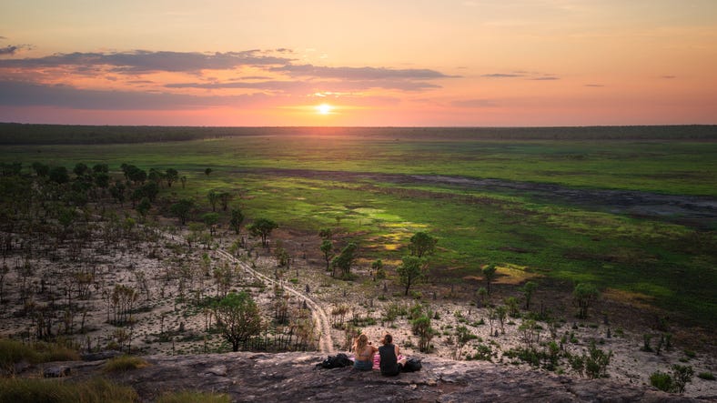 Couple watching sunset overlooking Ubirr