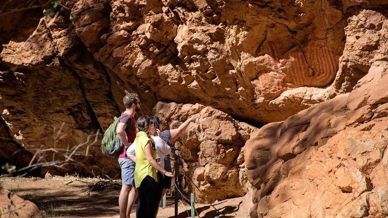 Group viewing aboriginal rock art while exploring