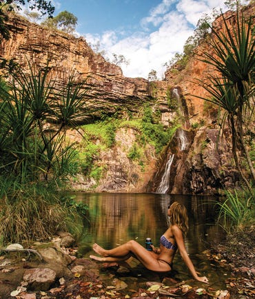 Lady sitting at the edge of the water at Sandy Creek Falls Litchfield National Park