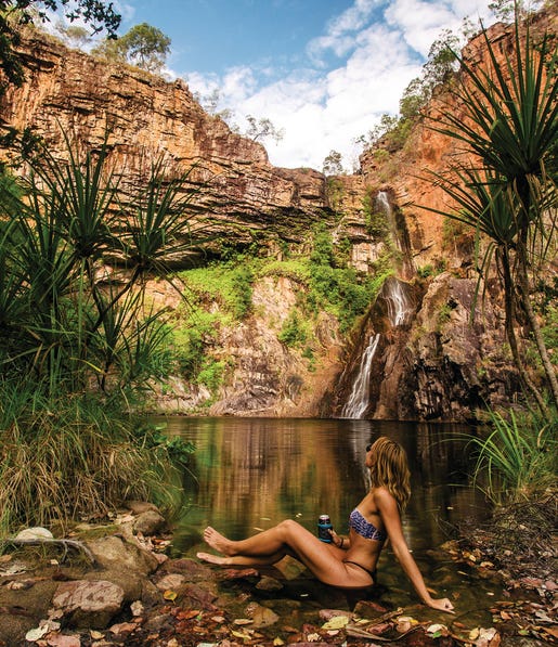 Lady sitting at the edge of the water at Sandy Creek Falls Litchfield National Park