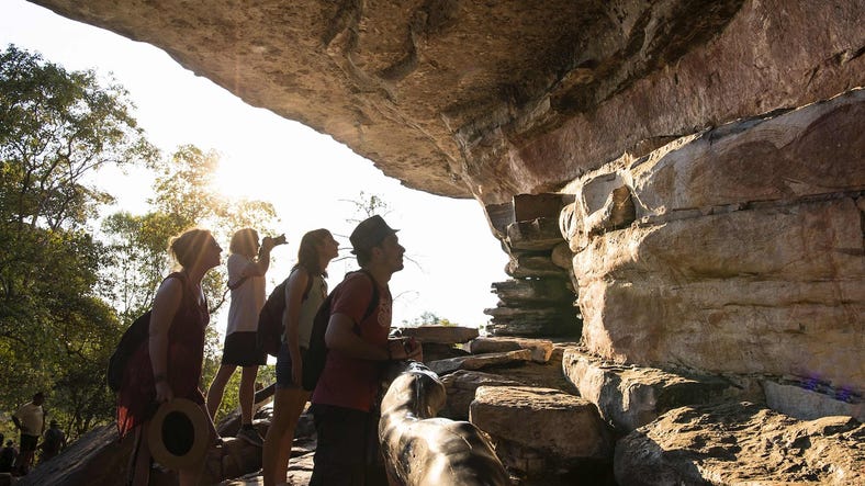 Group of visitors admiring the rock art in Ubirr