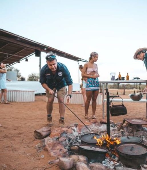 Man stoking the campfire at the earth sanctuary in Alice Springs.jpg