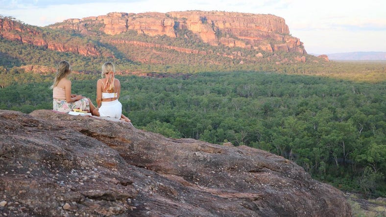 Two people sitting together on a rock at Nawurlandja lookout