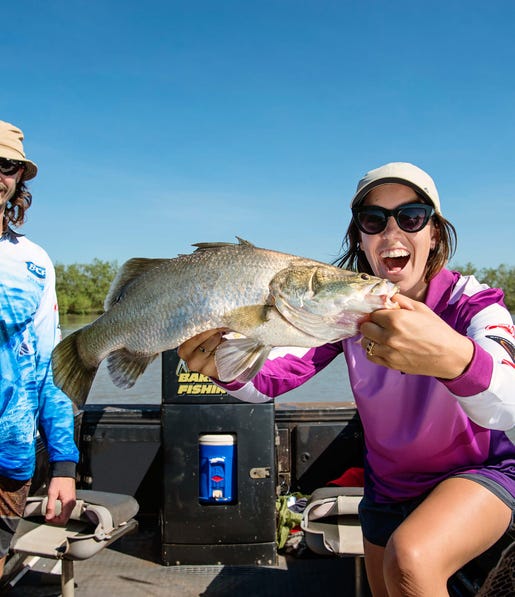 A lady holds a Barramundi caught at Shady Camp Billabong