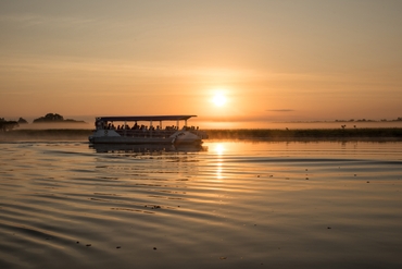 Group on a boat tour with Yellow Water Cruises at sunset