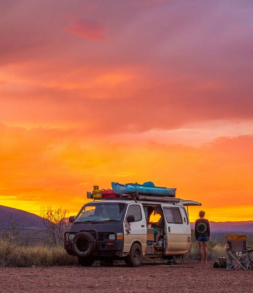 Girl with a van camping at sunset at Tjoritja-West MacDonnell NationalPark