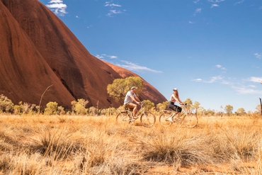 Couple on a bike ride around the base of Uluru
