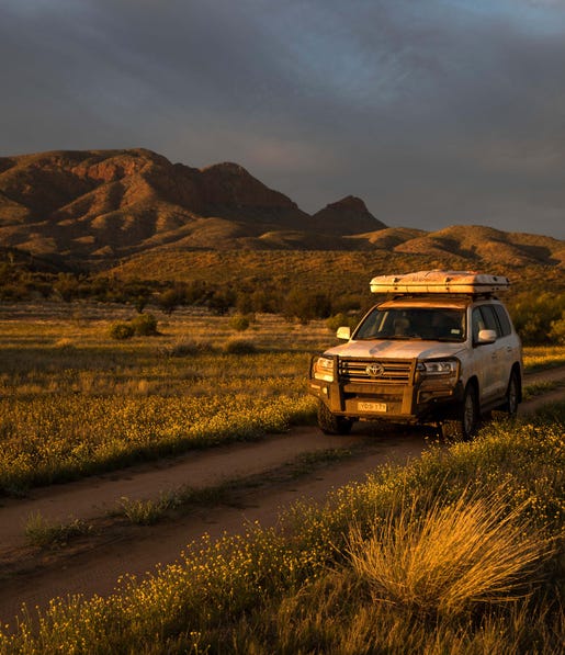 A car driving through the West MacDonnell Ranges near Alice Springs